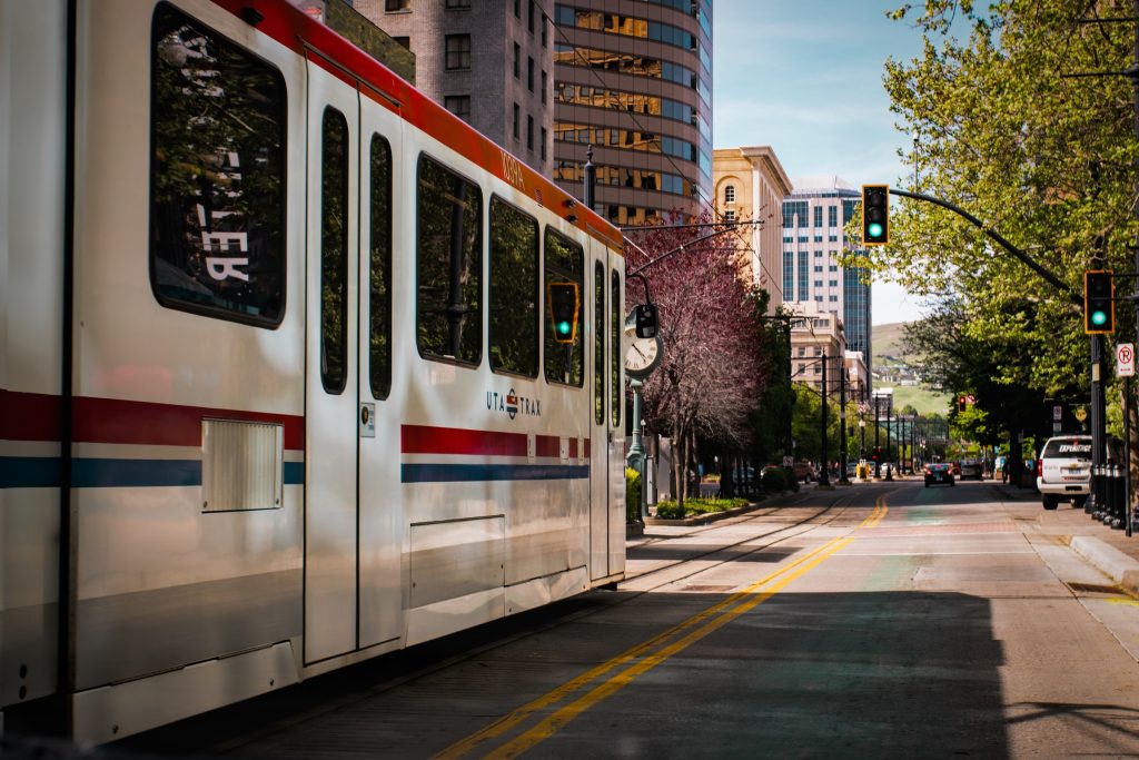Urban commuter train passing by modern skyscrapers in downtown cityscape