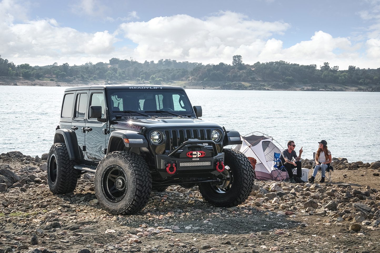 Jeep Wrangler Rubicon parked by lake side equipped with all-terrain tires for off-road performance