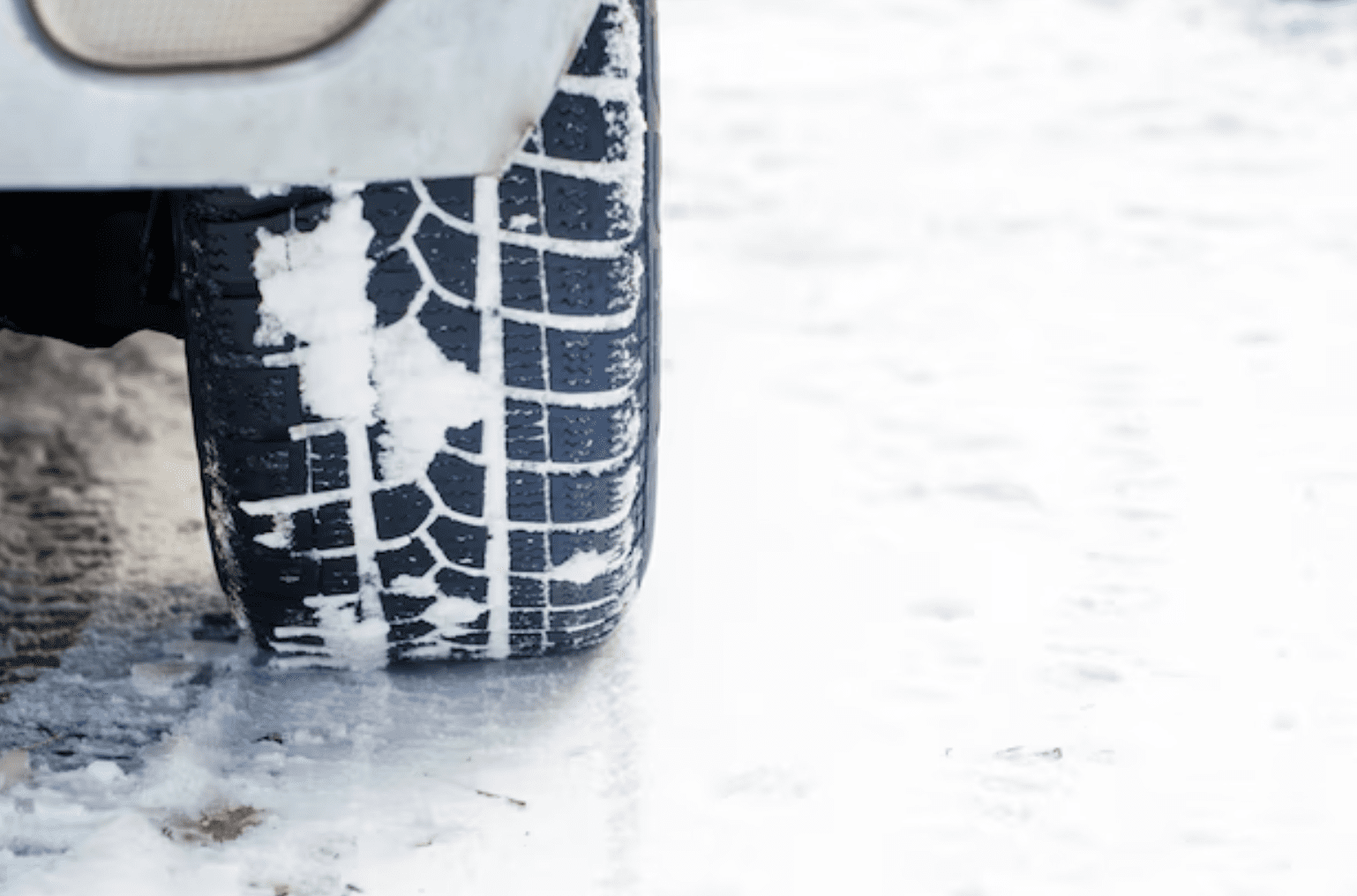 Close-up view of Blizzak winter tires on a snowy road.