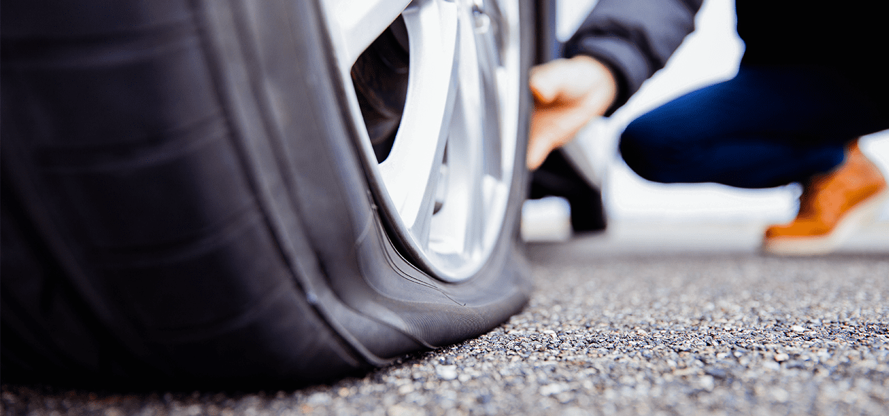 Burt Brothers technician inspecting a vehicle flat tire.