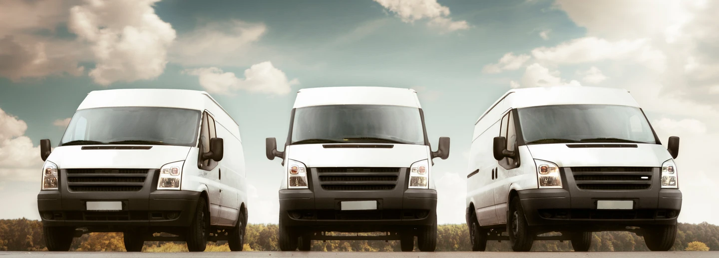 Fleet of white work vans serviced by Big Brand Tire & Service