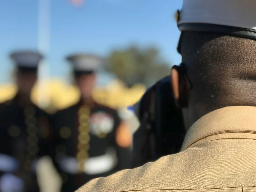 Marine in uniform facing a color guard